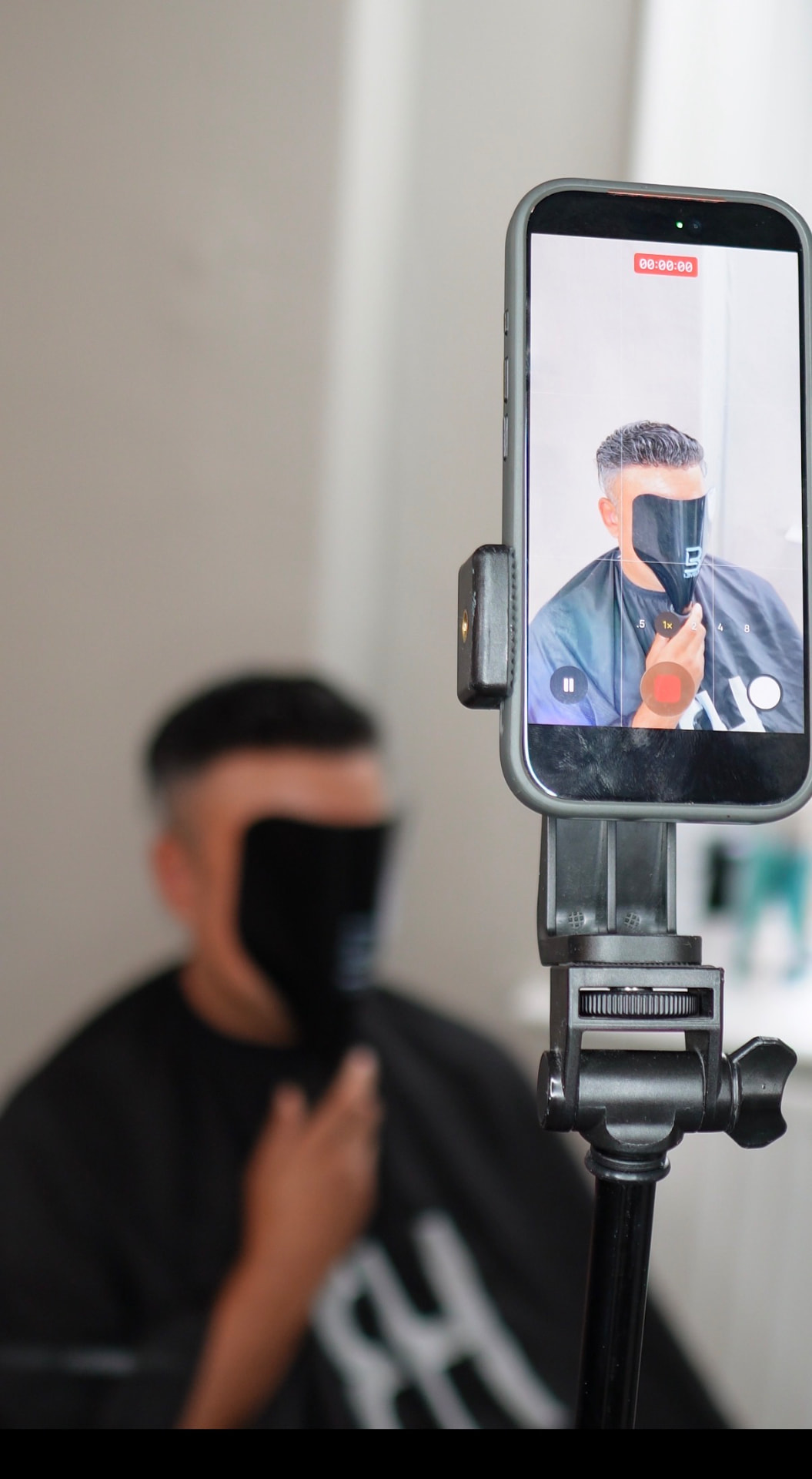 Filming a hair replacement transformation on a phone in the studio