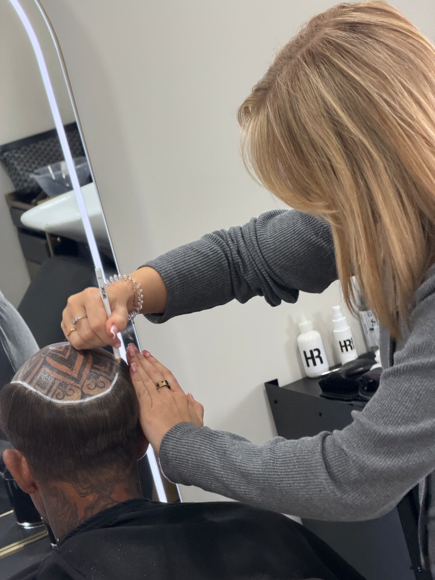 HRC specialist templating and fitting a hair system on a client during practical training